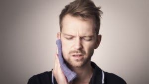 Man holding face in pain